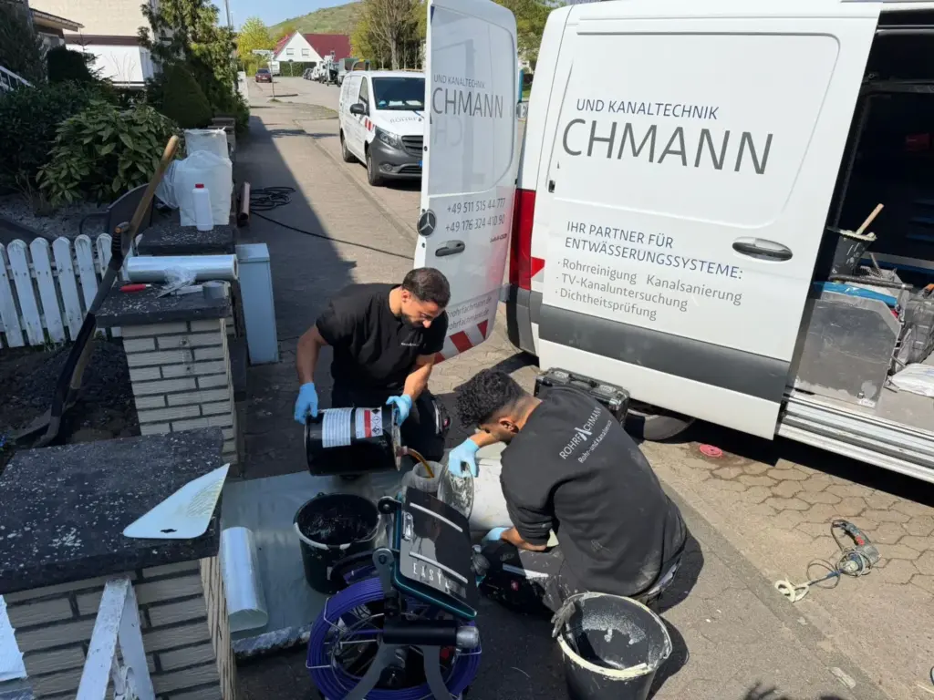 Zwei Techniker von Rohrfachmann bereiten Kanalkamera und Kabeltrommel am Fahrzeug vor