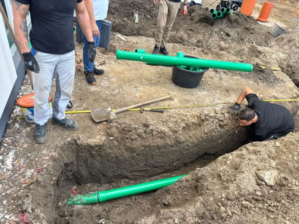 Offener Graben mit neuen Abwasserleitungen auf einem Neubaugrundstück